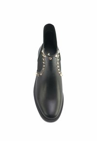 Must have nahkaneedid elastse külgedega, mille esiosas on rida metallnööpe aktsendiks. Sile tekstuur ja ümar varvas.