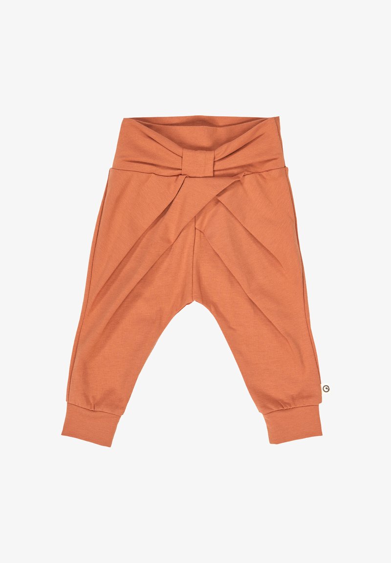 Světlé oranžové kalhoty pro batolata vyrobené z jemné tkaniny, s designem přes křížení v pase a zúženými lemy u kotníků.