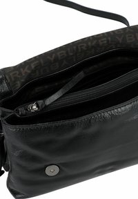 Borsa a tracolla in pelle nera con finitura testurizzata, dotata di una tasca interna con cerniera e chiusura a scatto metallica. Foderata con tessuto a motivo logo.