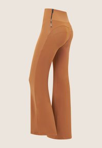 Pantaloni fitness svasati di un caldo colore marrone, realizzati in un tessuto liscio ed elastico. Presentano una vita alta e una piccola tasca con cerniera laterale.