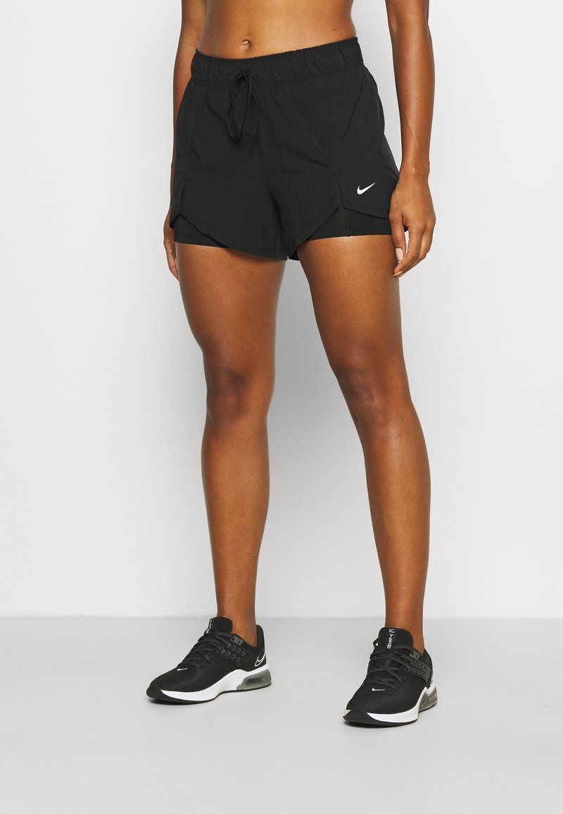 Shorts Nike noirs en tissu léger et texturé ; taille élastique ; et ourlet incurvé. Accompagnés de baskets noires avec des accents blancs.