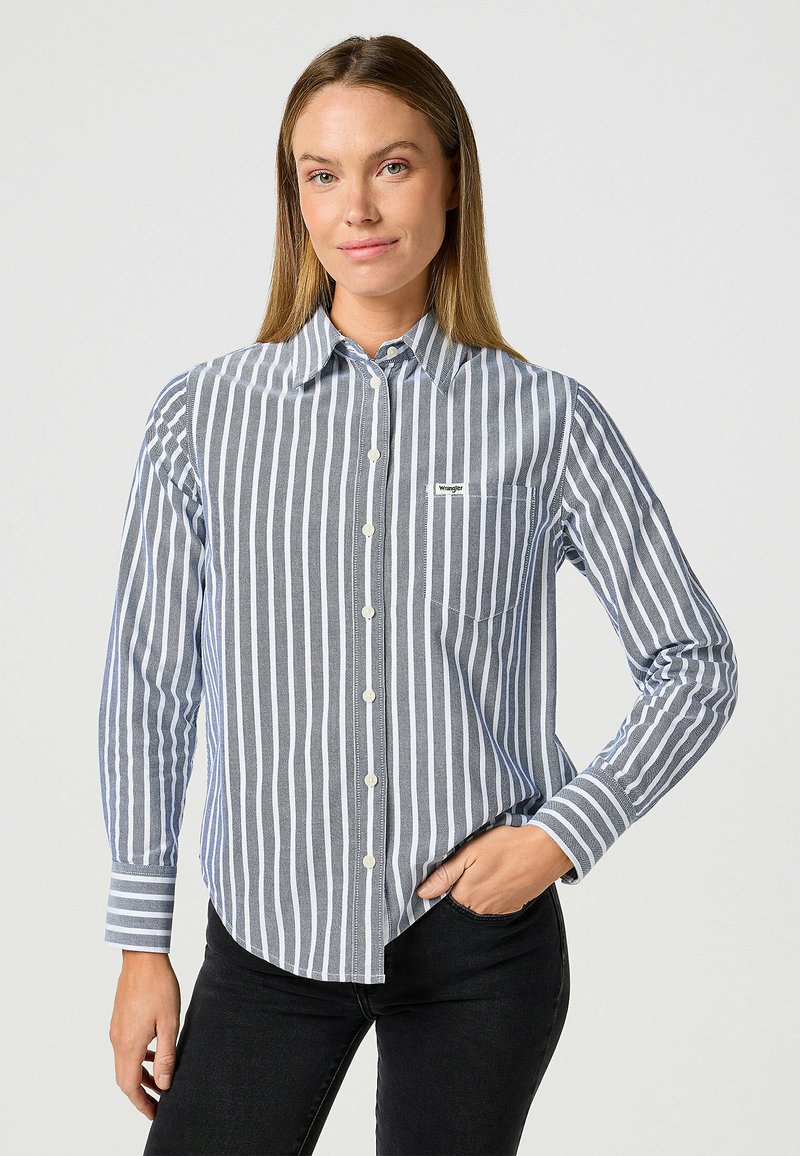 Blå och vit randig skjorta med knappar och långa ärmar, gjord av lättviktsmaterial, med en bröstficka och en subtil logotyp.