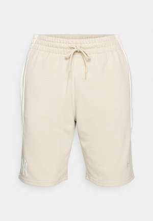 Bež kratke hlače od trenirke s elastičnom trakom i vezicom. Bočne džepove i bijeli logo na lijevom rubu. Izrađene su od mekanog materijala.