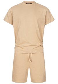 Beige T-shirt med korte ærmer og matchende shorts med snøre, afslappet hjemmebeklædning med ensartet, glat stoftekstur.