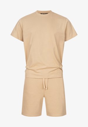 Beżowy zestaw składający się z krótkiego T-shirtu z krótkim rękawem oraz szortów z troczkiem, casualowa odzież do relaksu, o gładkiej, jednolitej fakturze tkaniny.