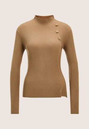 Ribbed camel-brown long-sleeve sweater with mock neck, three small gold bow-shaped pins near left shoulder, and a side slit hem.