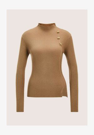 Rippiges, kamelbraunes Langarmshirt mit Stehkragen, drei kleinen goldenen Schleifen-Pins nahe der linken Schulter und einem seitlichen Schlitzsaum.