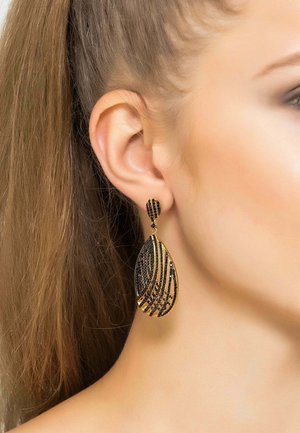 Gold-tone drop earrings featuring a teardrop shape with black bead detailing and wavy striped design. Secure backing for easy wear.