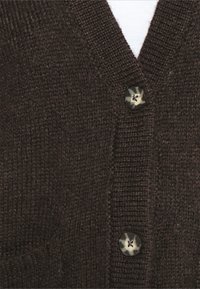 Hnědý pletený kardigan s výstřihem do V, který má dva knoflíky v melírovaném designu a texturovanou tkaninu, která zdůrazňuje jeho teplo.