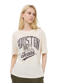 Kremowa koszulka t-shirt o luźnym kroju, z grafiką w ciemnofioletowym kolorze z napisem "Houston Let's Go Texas", z motywem hełmu futbolowego.