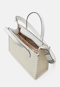 Sac à main rectangulaire beige et blanc à motif chevron avec des poignées en cuir blanc et une ouverture zippée en haut dévoilant une poche intérieure zippée.