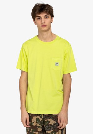 Neon yellow cotton t-shirt with a round neckline, short sleeves, and a chest pocket featuring a logo patch. Worn with camouflage shorts.