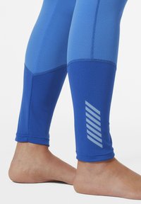 Modré legíny s kombinací texturované a hladké látky. Má odrazový pruhový design na spodní části nohy. Přiléhavý tapered design.