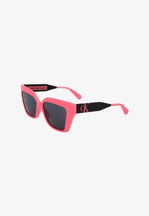 Occhiali da sole Calvin Klein Jeans rosa e neri con grandi lenti quadrate scure e logo CK sulle aste nere.