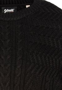 Schwarzer Strickpullover mit strukturierter Zopfmusterung, rundem Kragen und einem angenähten "Schott"-Label am Halsausschnitt.