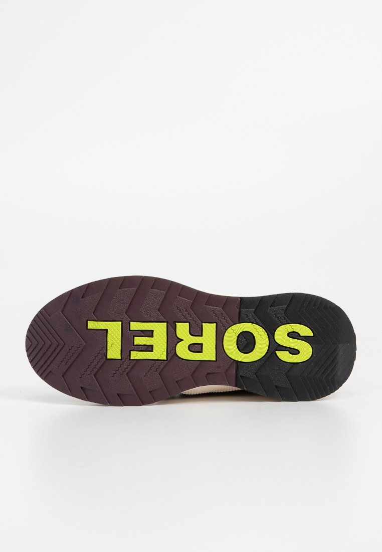 Sorel-Schuhsohle mit einem schwarzen und gelben Gummi-Material, strukturiertem Profilmuster und deutlicher "SOREL"-Markierung in Gelb.