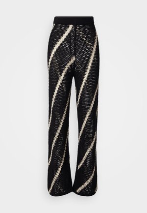 Strikkede svarte bukser med bred ben-design, med dristige, diagonale hvite striper. Elastisk midjebånd og teksturert stoff.