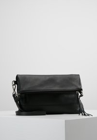 Czarna skórzana torba na ramię z ziarnistą fakturą, klapką na zatrzask, zamkiem błyskawicznym i odpinanym paskiem ozdobionym chwostem.