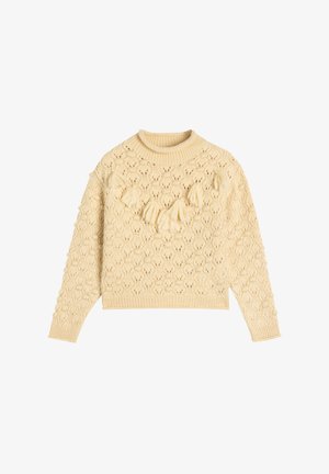 Suéter de punto color crema con un patrón texturizado, cuello redondo, mangas largas y borlas decorativas en la parte delantera.