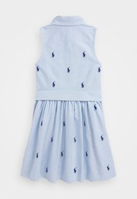 Ljusblå ärmlös klänning med krage, broderade marinblå polo-logotyper och en veckad kjol med sidofickor.