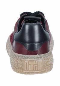 Bordeauxfarbene Sneaker mit gepolstertem schwarzen Fersenbereich, strukturierten Gummisohlen und einem eingeprägten Logo auf der Rückseite. Hergestellt aus Leder und Wildleder.