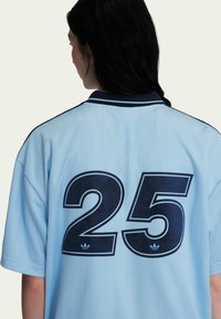 Lichtblauw sportjersey met korte mouwen, een marineblauwe kraag en groot marineblauw nummer "25" op de achterkant. Gestructureerde stof met verticale strepen.