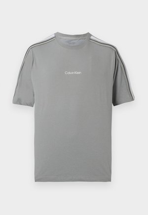 Grå T-shirt med korte ærmer med sorte striber på skuldre og ærmer og hvid "Calvin Klein"-logo på brystet.
