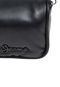 Borsa in pelle nera con una texture liscia, corpo arrotondato e dettagli del logo lucidi. Presenta una tracolla e chiusura con zip.