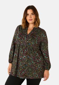 Schwarze Bluse mit buntem Paisleymuster, langen Ärmeln und V-Ausschnitt. Hergestellt aus leichtem Stoff mit gerafften Details an der Brust.