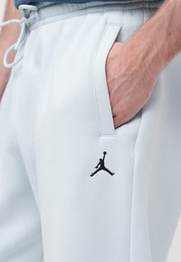 Φωτεινό γαλάζιο παντελόνι φούτερ από μαλακό ύφασμα, με μαύρο λογότυπο Jumpman, ελαστική μέση και τσέπες στο πλάι.