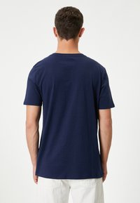 Mörkblå bomull t-shirt med korta ärmar och rund halsringning, med en slät yta och en avslappnad passform.