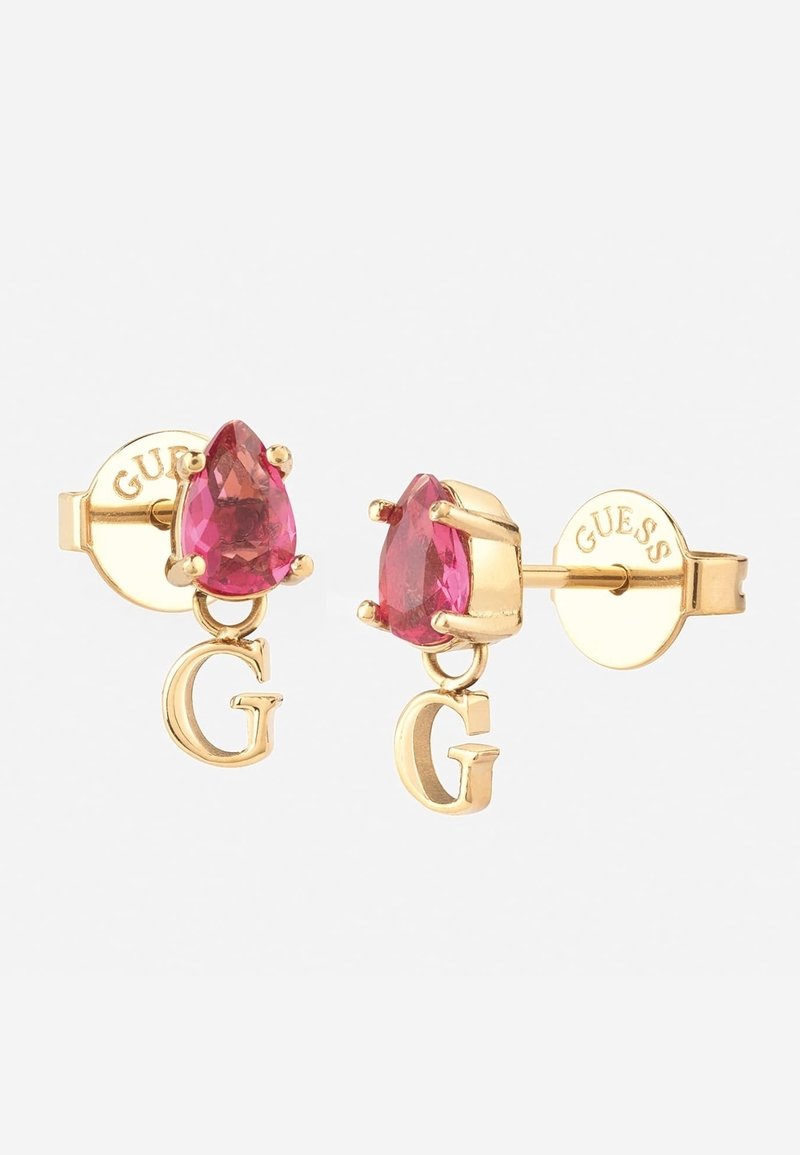 Boucles d’oreilles clous en or avec pierres précieuses roses en forme de larme et breloques pendantes en forme de lettre G, sécurisées par des fermoirs à poussette gravés de "GUESS".