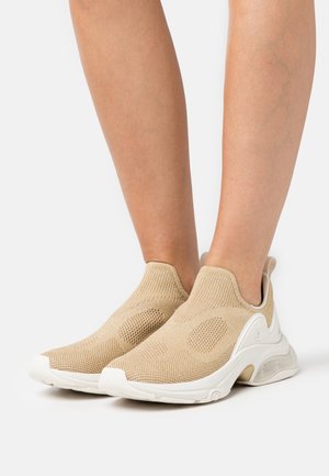 Sneaker beige slip-on in tessuto a rete, con tomaia testurizzata, suola bianca e colletto imbottito. Presenta dettagli circolari sui lati.