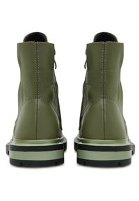 Stivaletti green con tomaia in pelle liscia, lati texturizzati e una suola a strisce contrastanti nera e verde chiaro. Dettaglio di cucitura minimal.