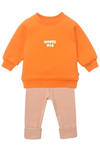Oranger Baumwoll-Sweatshirt mit weißem "AMORE MIO"-Text, kombiniert mit beige-orange gestreiften Leggings mit aufgerollten Säumen.
