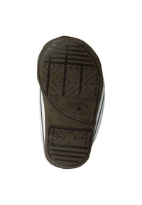 Semelle en caoutchouc noir avec un motif de semelle en losanges et lignes, arborant un logo "Converse All Star", attachée à une tige en toile blanche.