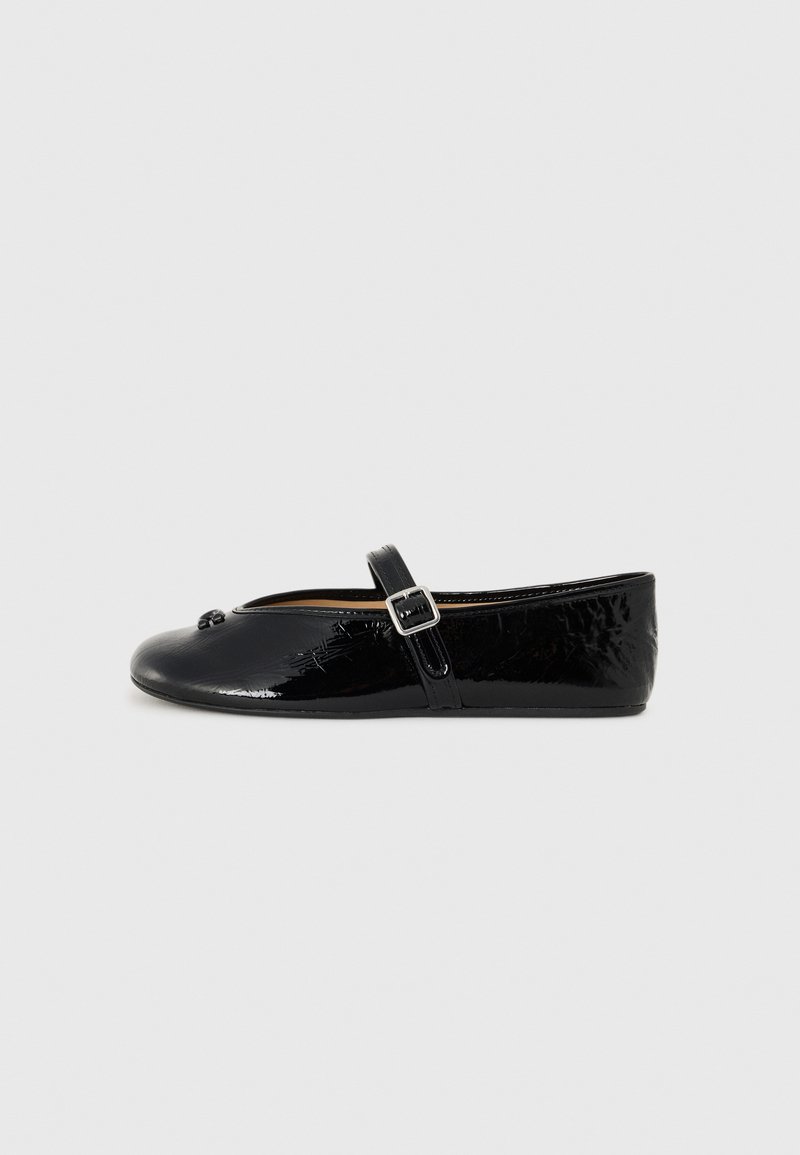 Black patent leather flat shoe with a round toe, Mary Jane strap, silver buckle, and subtle floral texture on the upper.