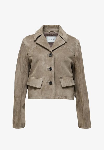 Beige nahkaja nahast lühike jakk, millel on terav krae, esine nööpidega sulgemine ja kaks klapiga taskut vööl. Sile tekstuur ja kohandatud lõige.