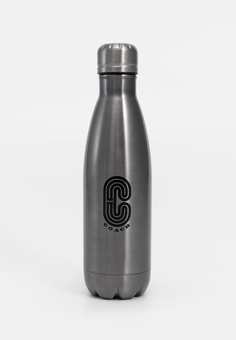 Botella de agua de acero inoxidable, acabado gris mate, diseño cónico, tapa de rosca plateada, cuenta con un logo negro con el texto "COACH".
