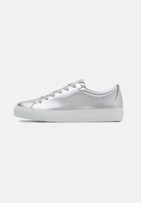Sneaker métallique argenté avec une texture lisse, bout arrondi et semelle en caoutchouc blanche. Dispose de lacets plats et d'un design minimaliste.