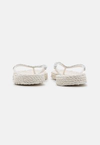 Espadrillas bianche con suola in juta intrecciata testurizzata, con accenti di strass trasparenti sulle sottili cinghie e un design aperto sul retro.