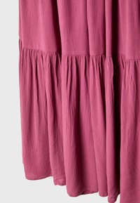 Rosa Kleid aus strukturiertem Stoff, mit einem gestuften Design, das am Boden geraffte Abschnitte und einen glatten oberen Teil aufweist.
