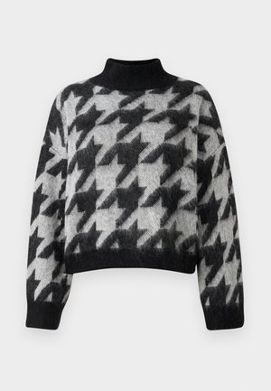 Maglione corto in bianco e grigio con colletto alto, caratterizzato da un motivo pied de poule e una texture morbida. Maniche lunghe e larghe che si stringono ai polsi.