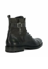 Black leather ankle boot with a smooth finish, decorative side zipper, and textured accents. Sturdy rubber sole with horizontal grooves.