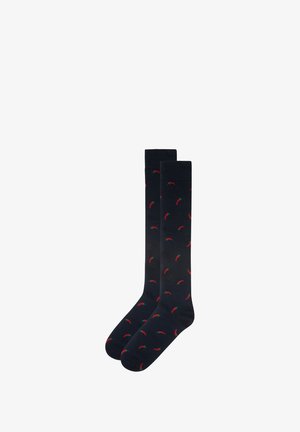 Chaussettes navy avec un motif de piments rouges, fabriquées dans un matériau doux et extensible ; design montantes jusqu'au genou avec des poignets côtelés.