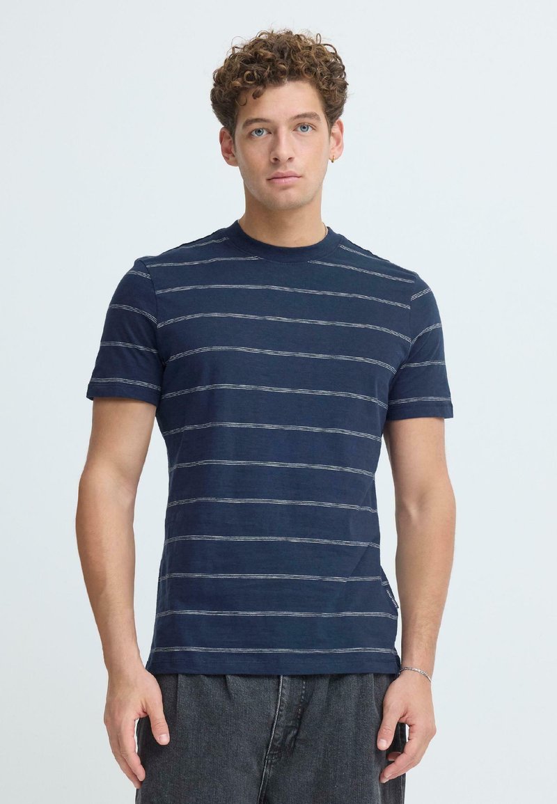 Κοντομάνικο μπλουζάκι σε ναυτικό μπλε με λευκές οριζόντιες ρίγες, στρογγυλή λαιμόκοψη, βαμβακερό υλικό και άνετη εφαρμογή.