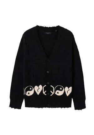 Sort cardigan med knapper med slidte detaljer og et hvidt mønster af yin-yang-symboler og knuste hjerter langs den nederste kant.