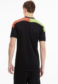 Svart träningsskjorta med korta ärmar, med kontrasterande orange och gröna detaljer på axlarna. Slät textur, enkel design.