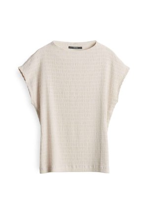 Light beige short-sleeve top with a textured surface featuring a grid pattern. Round neck design, relaxed fit with wide sleeves.