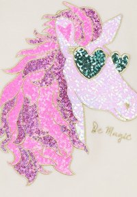 Testa di unicorno con paillettes rosa e viola, occhiali a forma di cuore, contornata in oro, con il testo "Sii Magia" in carattere dorato.